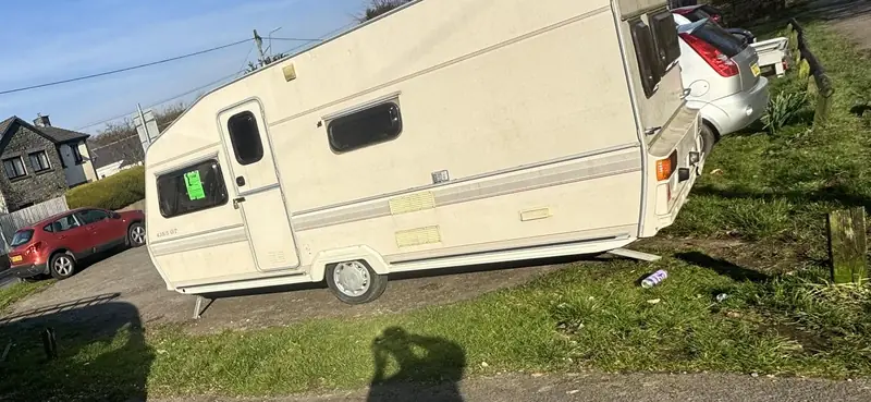 White touring caravan on a driveway, ready to be moved